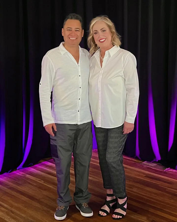 Dr. Gian and Tracy Villatoro standing together on stage, both in white shirts