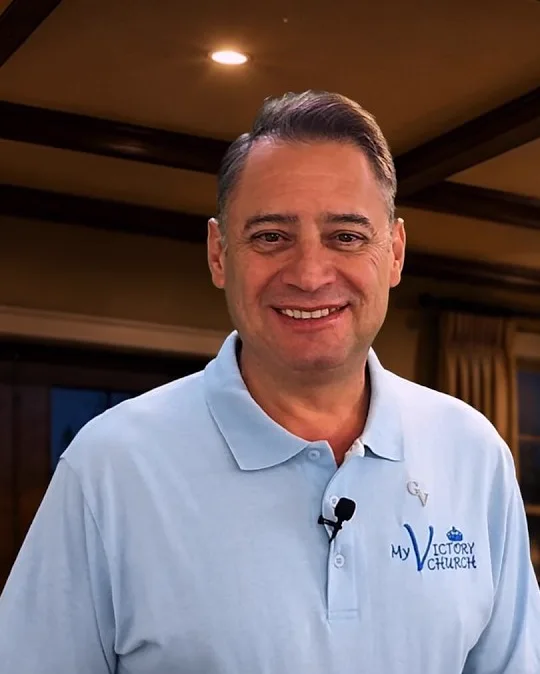 Dr. Gian teaching, smiling, in a light blue shirt
